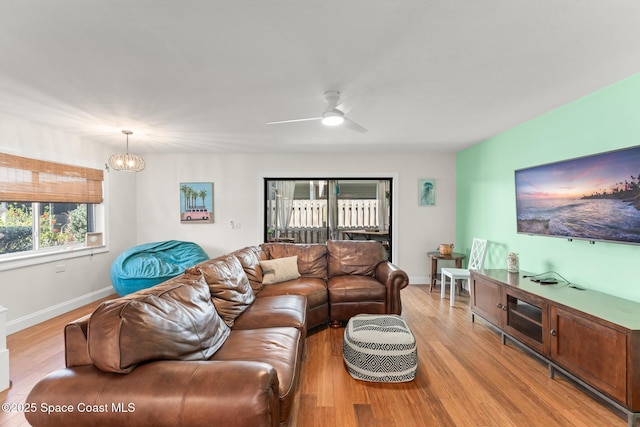 1710 Atlantic St Unit 5E, Melbourne Beach, FL 32951 - living room with light wood finished floors, ceiling fan, and a chandelier