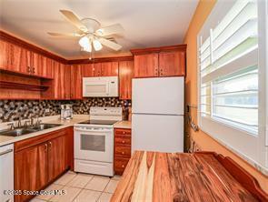 55 Woodland Dr Unit 206, Vero Beach, FL 32962 - kitchen with white appliances, light countertops, and decorative backsplash