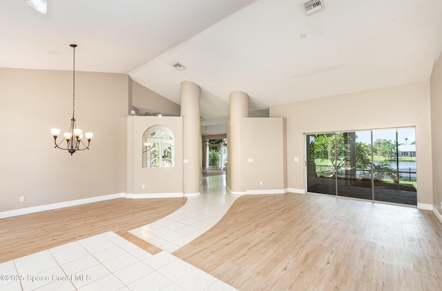 465 Apache Trl, Merritt Island, FL 32953 - unfurnished living room featuring light tile patterned floors, a chandelier, healthy amount of natural light, and lofted ceiling