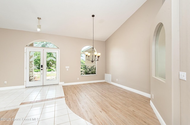 465 Apache Trl, Merritt Island, FL 32953 - unfurnished dining area with light tile patterned floors, a chandelier, arched walkways, and high vaulted ceiling