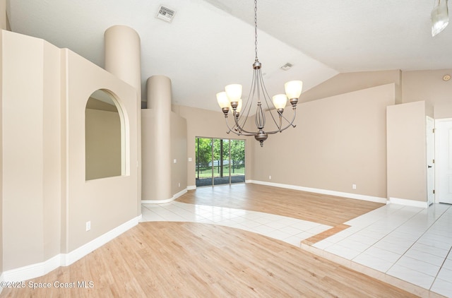 465 Apache Trl, Merritt Island, FL 32953 - empty room featuring light tile patterned floors, vaulted ceiling, and a chandelier