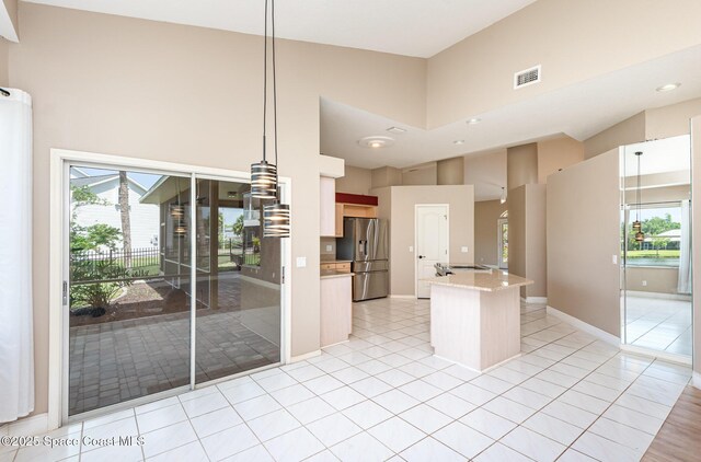 465 Apache Trl, Merritt Island, FL 32953 - kitchen featuring stainless steel fridge with ice dispenser, a high ceiling, healthy amount of natural light, light tile patterned flooring, and stovetop