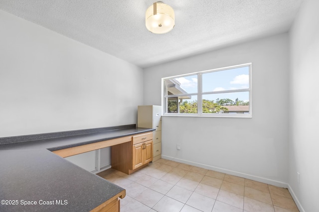 2812 Denison Ct, Cocoa, FL 32926 - unfurnished office featuring built in desk, a textured ceiling, and light tile patterned floors