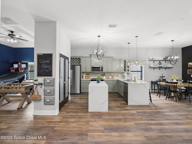 3662 Brantley Cir, Rockledge, FL 32955 - kitchen featuring appliances with stainless steel finishes, a chandelier, a peninsula, dark wood-style flooring, and a center island