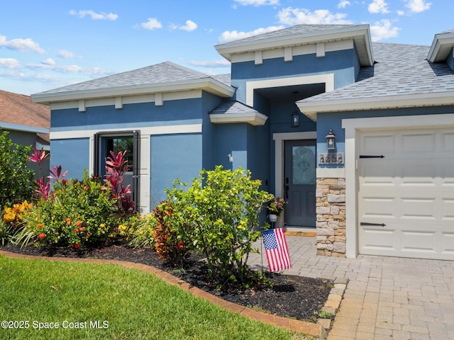 3662 Brantley Cir, Rockledge, FL 32955 - view of front of property featuring stone siding, stucco siding, an attached garage, a high end roof, and roof with shingles