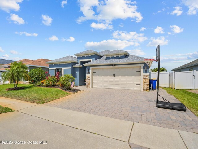 3662 Brantley Cir, Rockledge, FL 32955 - prairie-style home featuring stone siding, an attached garage, a gate, and decorative driveway