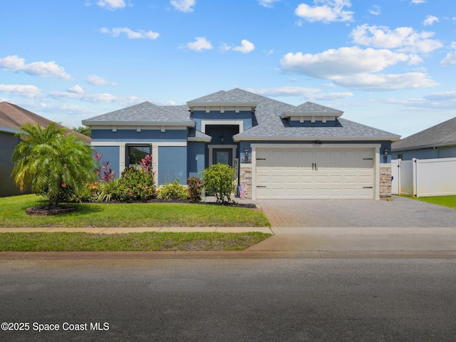 3662 Brantley Cir, Rockledge, FL 32955 - prairie-style house with driveway, an attached garage, stone siding, roof with shingles, and stucco siding