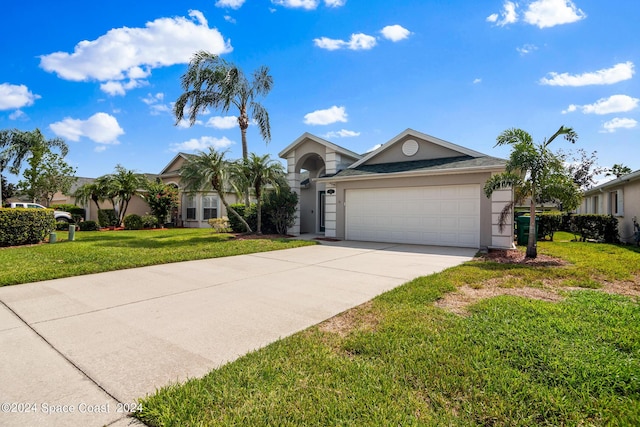 621 Misty Creek Dr, Melbourne, FL 32940 - view of front of house with stucco siding, a garage, driveway, and a front lawn