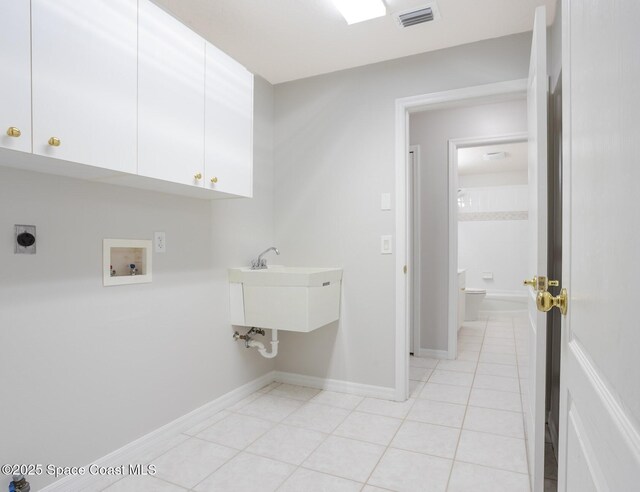 621 Misty Creek Dr, Melbourne, FL 32940 - laundry room featuring cabinet space, light tile patterned flooring, hookup for an electric dryer, and hookup for a washing machine