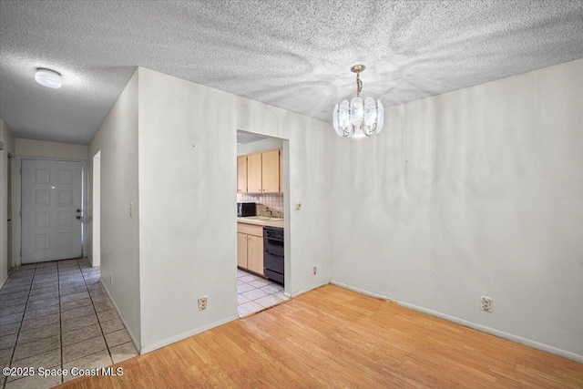 1289 Cheney Hwy Unit B, Titusville, FL 32780 - unfurnished dining area with a chandelier, light wood-style flooring, and a textured ceiling