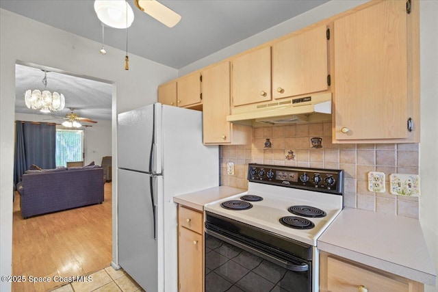 1289 Cheney Hwy Unit B, Titusville, FL 32780 - kitchen with electric range, under cabinet range hood, a ceiling fan, freestanding refrigerator, and light brown cabinetry