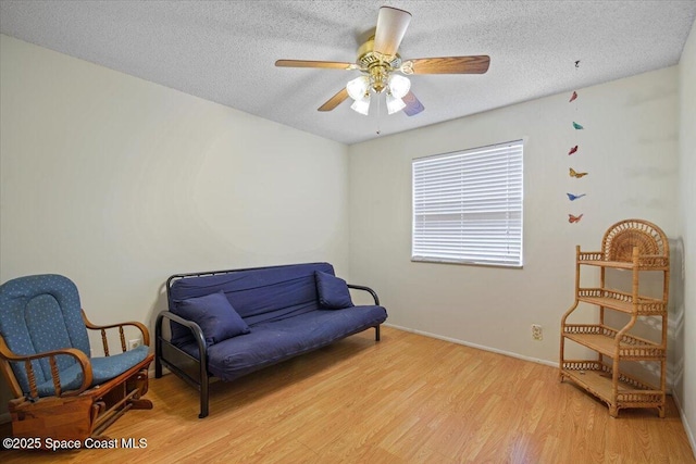 1289 Cheney Hwy Unit B, Titusville, FL 32780 - living area featuring light wood-style flooring, a textured ceiling, and a ceiling fan