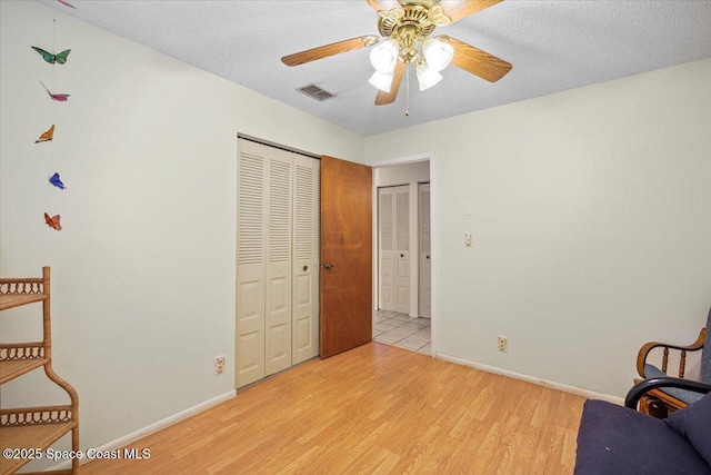 1289 Cheney Hwy Unit B, Titusville, FL 32780 - living area featuring light wood-style floors, ceiling fan, and a textured ceiling