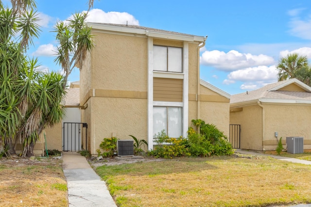 1441 Sheafe Ave NE Unit 104, Palm Bay, FL 32905 - rear view of property featuring stucco siding, a yard, and a gate