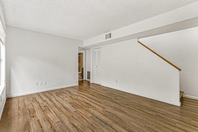 1441 Sheafe Ave NE Unit 104, Palm Bay, FL 32905 - unfurnished living room with wood finished floors, a textured ceiling, and stairs