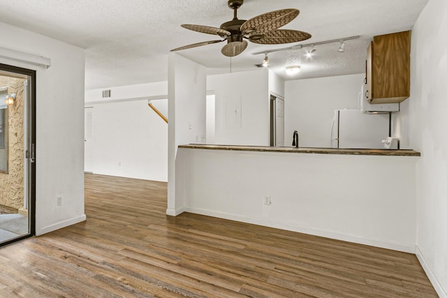 1441 Sheafe Ave NE Unit 104, Palm Bay, FL 32905 - unfurnished living room featuring ceiling fan, wood finished floors, rail lighting, and a textured ceiling