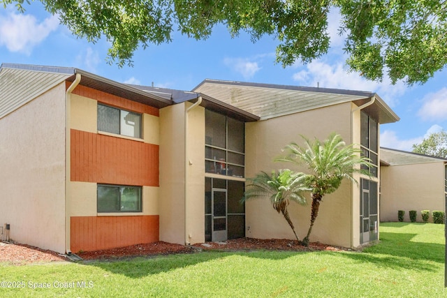 2358 Golf Lake Cir Unit 212, Melbourne, FL 32935 - rear view of property with a lawn and stucco siding