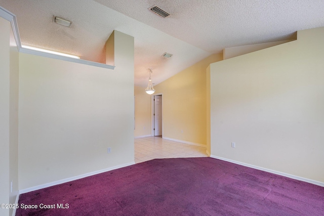 146 Oakcrest Ave NE, Palm Bay, FL 32907 - empty room featuring carpet flooring, lofted ceiling, tile patterned floors, and a textured ceiling