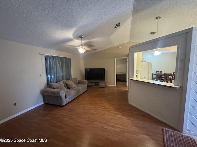 1385 Salerno Ave SE, Palm Bay, FL 32909 - living room featuring a ceiling fan, a textured ceiling, wood finished floors, and lofted ceiling