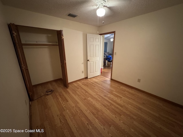 1385 Salerno Ave SE, Palm Bay, FL 32909 - unfurnished bedroom with light wood finished floors, a textured ceiling, a closet, and ceiling fan