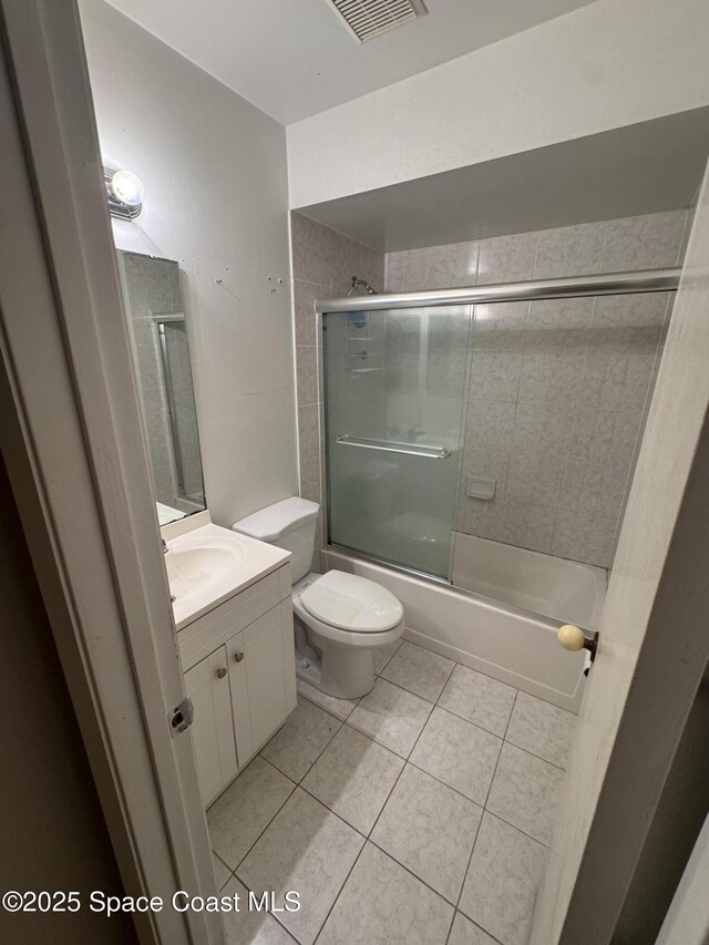 1385 Salerno Ave SE, Palm Bay, FL 32909 - full bathroom featuring vanity, bath / shower combo with glass door, and tile patterned floors