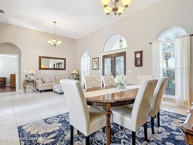 603 Cross Creek Dr, Sebastian, FL 32958 - dining room featuring a chandelier, light tile patterned floors, plenty of natural light, and arched walkways