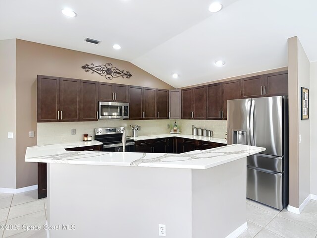 603 Cross Creek Dr, Sebastian, FL 32958 - kitchen featuring appliances with stainless steel finishes, dark brown cabinets, light tile patterned flooring, lofted ceiling, and tasteful backsplash
