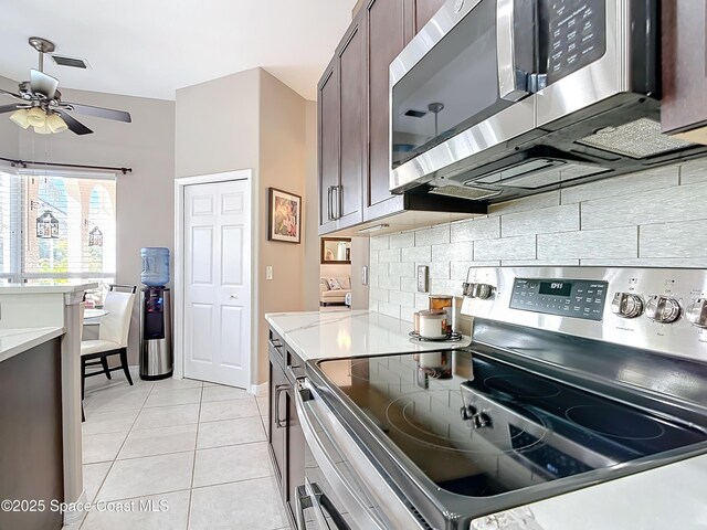 603 Cross Creek Dr, Sebastian, FL 32958 - kitchen with stainless steel appliances, backsplash, a ceiling fan, dark brown cabinets, and light tile patterned floors
