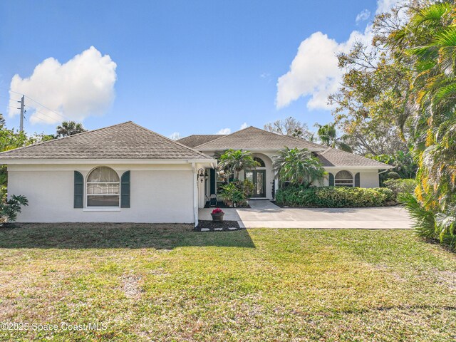 603 Cross Creek Dr, Sebastian, FL 32958 - view of front of house with stucco siding, a front yard, driveway, and roof with shingles