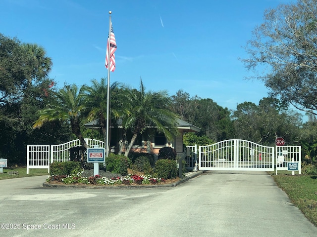 603 Cross Creek Dr, Sebastian, FL 32958 - view of asphalt road featuring a gate, a gated entry, and traffic signs