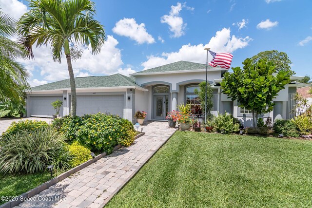 4448 Heaton Park Trl, Rockledge, FL 32955 - view of front facade with stucco siding, an attached garage, a front lawn, a shingled roof, and driveway