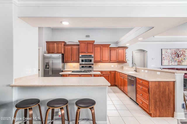 4448 Heaton Park Trl, Rockledge, FL 32955 - kitchen with a peninsula, appliances with stainless steel finishes, arched walkways, a breakfast bar area, and light countertops