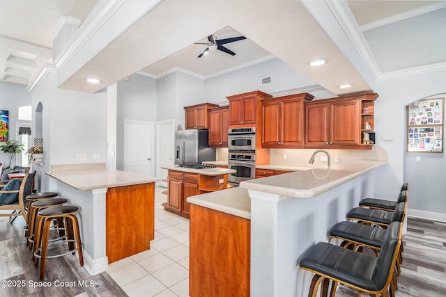 4448 Heaton Park Trl, Rockledge, FL 32955 - kitchen featuring a peninsula, a kitchen breakfast bar, stainless steel appliances, ceiling fan, and crown molding