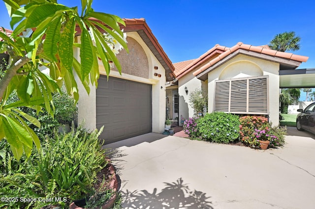 623 Manatee Dr, Satellite Beach, FL 32937 - view of front of home with driveway, stucco siding, an attached garage, and a tiled roof