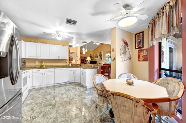 623 Manatee Dr, Satellite Beach, FL 32937 - kitchen featuring white appliances, a ceiling fan, a peninsula, white cabinetry, and lofted ceiling