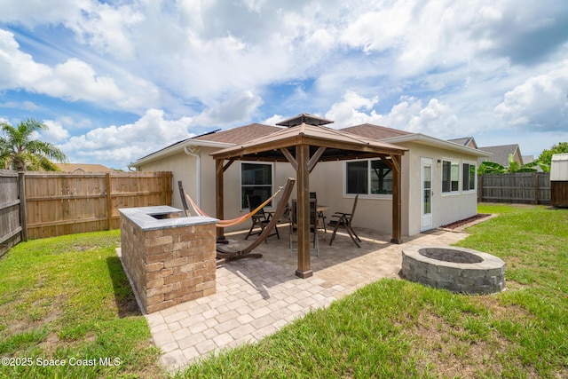 967 Sabal Grove Dr, Rockledge, FL 32955 - back of property featuring a fire pit, a gazebo, stucco siding, a fenced backyard, and a patio