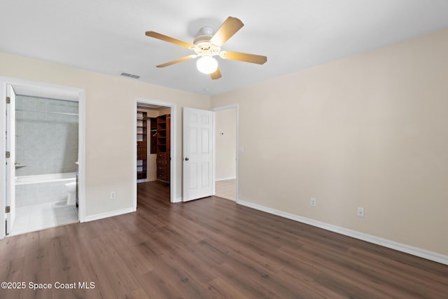 967 Sabal Grove Dr, Rockledge, FL 32955 - unfurnished bedroom with wood finished floors, a walk in closet, ensuite bathroom, and ceiling fan