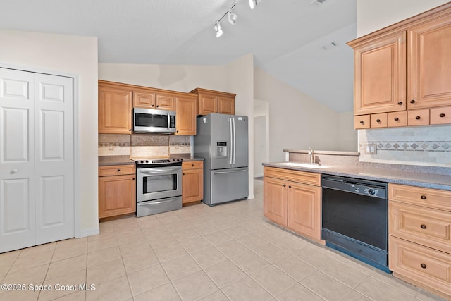 967 Sabal Grove Dr, Rockledge, FL 32955 - kitchen with appliances with stainless steel finishes, vaulted ceiling, decorative backsplash, track lighting, and light tile patterned flooring