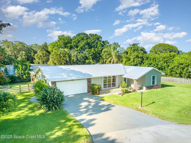 1995 Mark Twain Ln NE, Palm Bay, FL 32905 - view of front of property with an attached garage, driveway, a metal roof, stucco siding, and brick siding