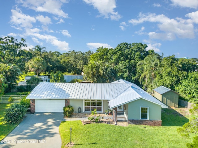 1995 Mark Twain Ln NE, Palm Bay, FL 32905 - view of front of house with stucco siding, a front yard, an attached garage, and driveway