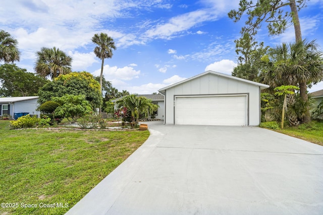 458 Stendal Rd NW, Palm Bay, FL 32907 - view of front facade featuring board and batten siding, driveway, a front lawn, and an attached garage