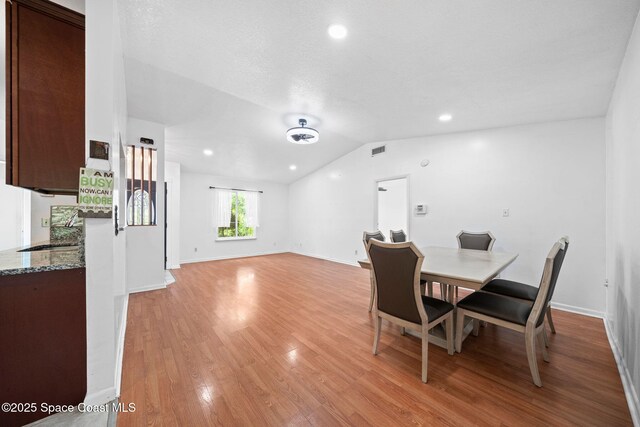458 Stendal Rd NW, Palm Bay, FL 32907 - dining room featuring vaulted ceiling, light wood finished floors, and recessed lighting