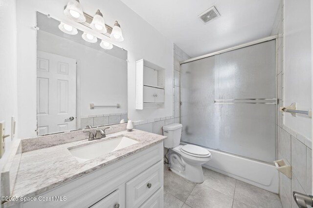 458 Stendal Rd NW, Palm Bay, FL 32907 - bathroom with vanity, tile patterned flooring, bath / shower combo with glass door, tile walls, and a wainscoted wall