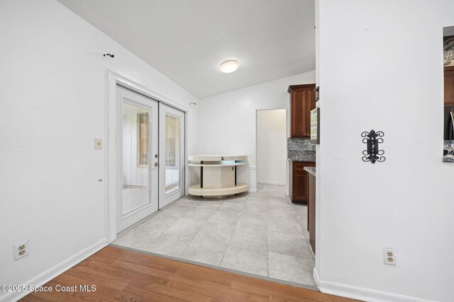 458 Stendal Rd NW, Palm Bay, FL 32907 - kitchen with vaulted ceiling, backsplash, and french doors