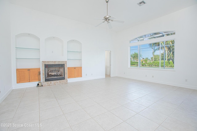 4180 Stoney Point Rd, Melbourne, FL 32940 - unfurnished living room with built in shelves, a fireplace, light tile patterned floors, and a ceiling fan