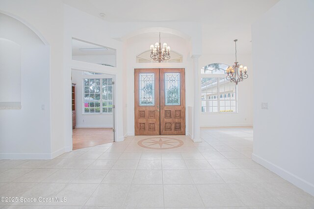 4180 Stoney Point Rd, Melbourne, FL 32940 - foyer featuring a chandelier, light tile patterned floors, arched walkways, and french doors
