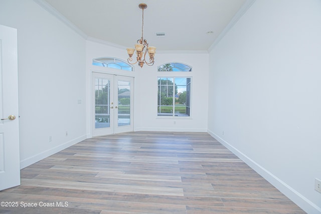 4180 Stoney Point Rd, Melbourne, FL 32940 - unfurnished dining area featuring a chandelier, crown molding, french doors, and wood finished floors