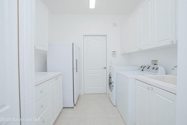 4180 Stoney Point Rd, Melbourne, FL 32940 - laundry area featuring washer and dryer, cabinet space, and light tile patterned floors