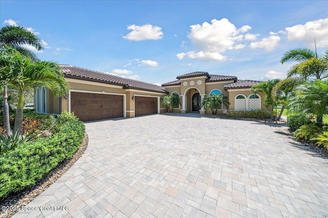 4464 Preservation Cir, Melbourne, FL 32934 - mediterranean / spanish-style house featuring stucco siding, decorative driveway, a garage, and a tiled roof