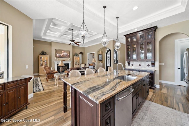 4464 Preservation Cir, Melbourne, FL 32934 - kitchen featuring arched walkways, appliances with stainless steel finishes, a ceiling fan, a kitchen bar, and light wood finished floors